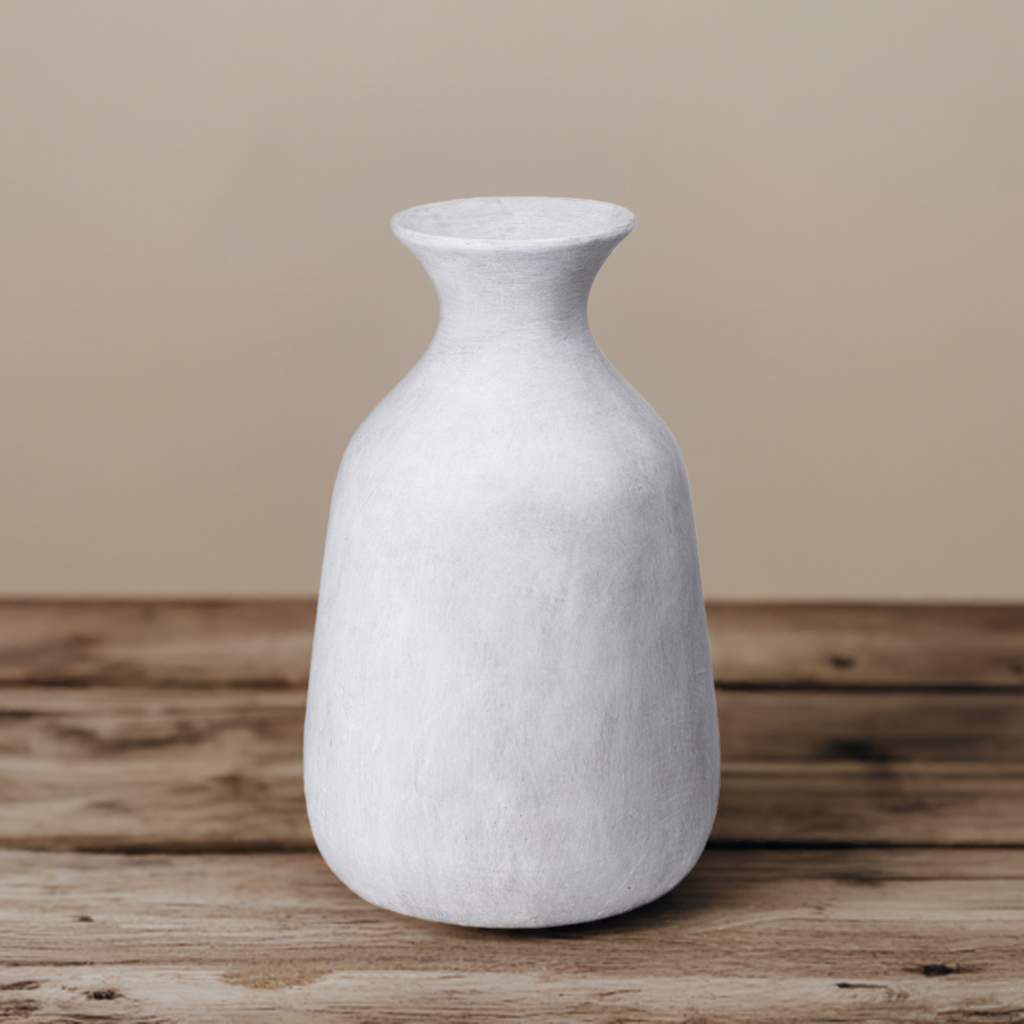 A white stone vase with a tapered neck on a wooden countertop