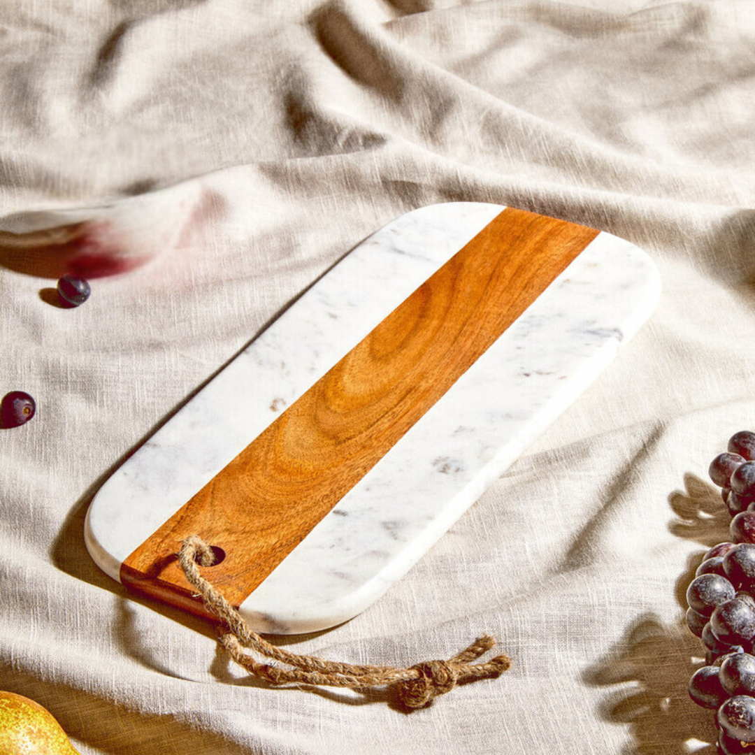 A marble and wood rectangular chopping board on a linen table cloth